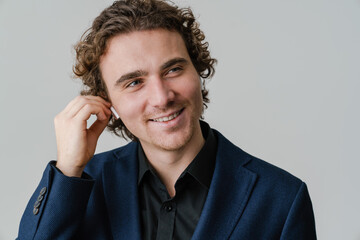 Joyful handsome man in wireless earphones smiling on camera