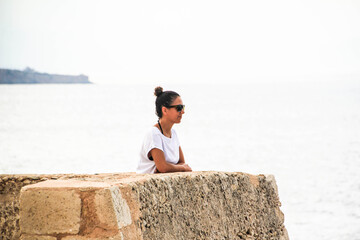 latin girl in a gazebo by the sea and with sunglasses	