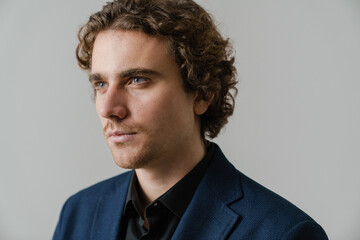 Confident handsome man in jacket posing and looking aside