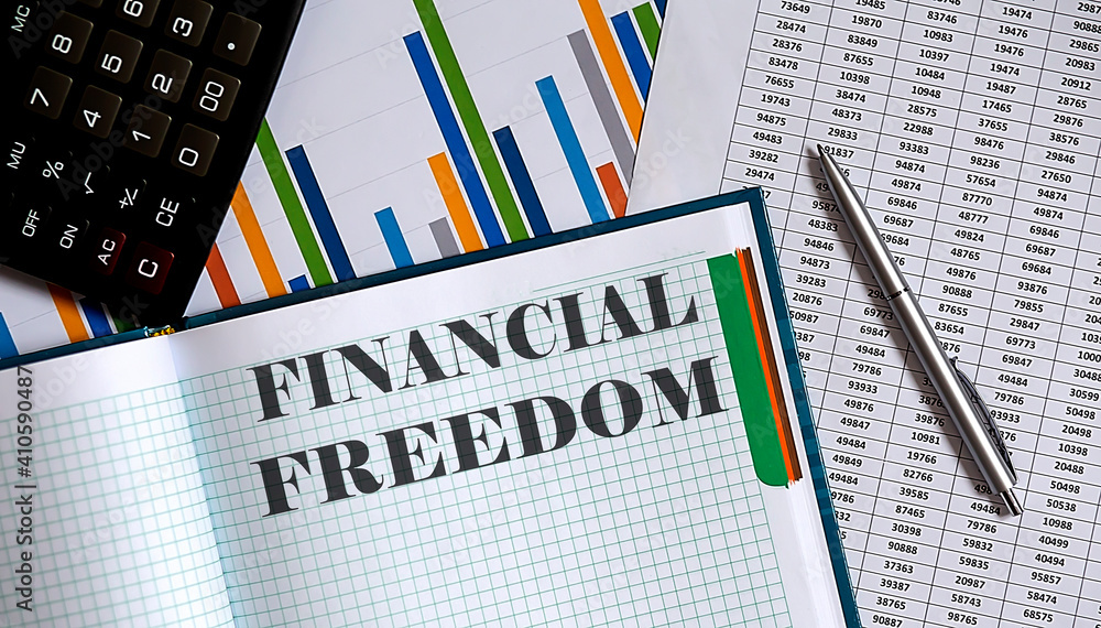 Poster closeup of notebook with text financial freedom on the chart background.