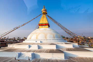 Buddhist Manuscripts inscribed on the golden bell with Boudhanath Stupa in the background.