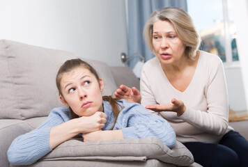 Portrait of offended girl turned away from her mature mother