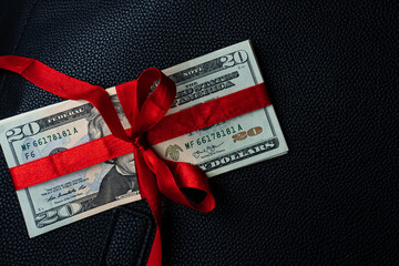 Money as a birthday present gift with red ribbon, dollar present