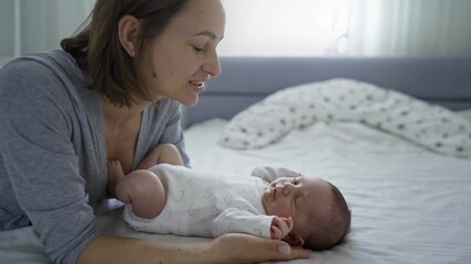Beautiful young mother with a baby girl at home. Close-up portrait woman with her cute baby have fun and enjoying togetherness, she rising up child and happily smiling. High quality 4k footage