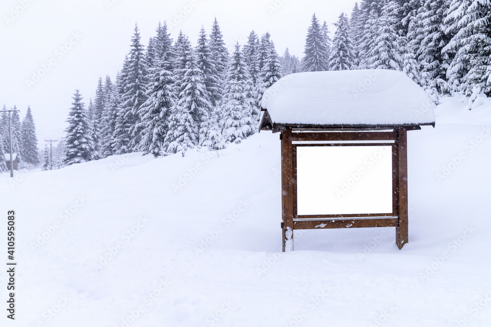 Poster view of an empty billboard with copy space for advertising poster and snowy fir trees background