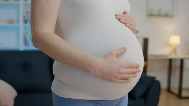 Young woman stroking belly, expecting baby, fetal development stages, trimester