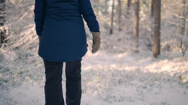 A woman walking in deep snow in a snowy winter forrest. Shot of the heavy boots in the snow.