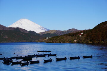 箱根芦ノ湖に並ぶボートと雪の降った富士山