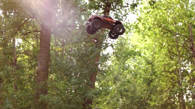 Jumping rc buggy car in slow motion. Radio controlled monster truck model jumping over the sandy hill.