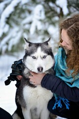 On a Sunny winter day, a young girl plays with a dog. The dog licks her face. Tenderness. Friendship. Horizontal orientation.
