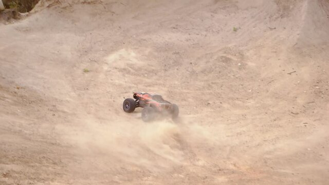 Jumping RC car on a bumpy sandy road. Offroad race with obstacles. Radio controlled monstrer truck.