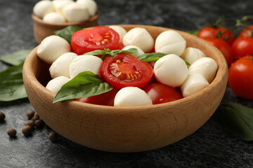 Concept of tasty eating with mozzarella cheese on black smokey background, close up