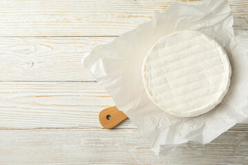 Cutting board with camembert cheese on wooden background