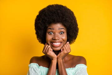 Photo portrait of excited girl waiting for surprise holding face with hands isolated on vivid yellow colored background