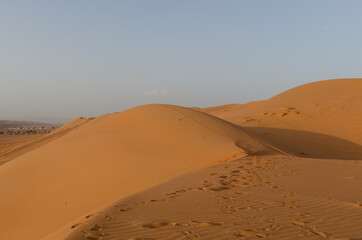 Fototapeta na wymiar Sands of the desert at wahiba, arabic landscape, sand dunes and forms at sunset