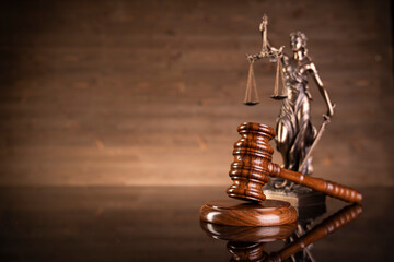 Law symbols composition on brown background. Gavel, scale, legal books and Themis sculpture. Place...