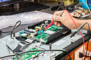disassembly and repair of  lcd tv  by engineer or technician in shop, selective focus.