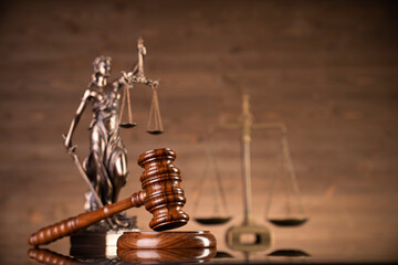 Law symbols composition on brown background. Gavel, scale, legal books and Themis sculpture. Place...