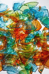 Mosaic of Broken Glass. Background of fragments of colored multicolored glass with blurred reflections on white background .Selective focus