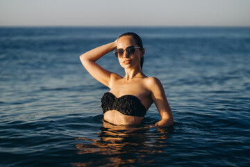 Pretty brunette woman relaxing on the beach at the sea.