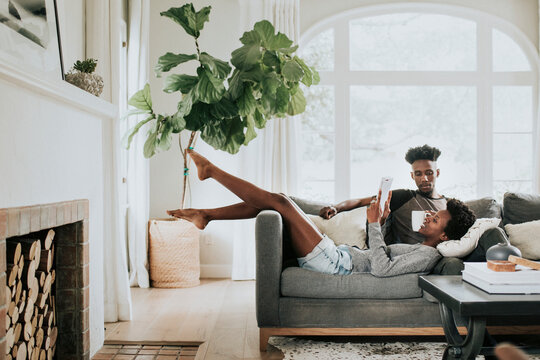 Cute romantic black couple reading a book on the couch