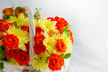 beautiful light wicker basket with yellow and red flowers. holiday, spring, congratulations