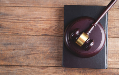 Gavel with book on a wood surface.