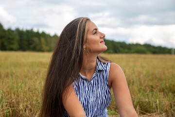 portrait of a beautiful swarthy caucasian young woman on a background of a field, nature.