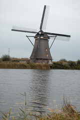 Dutch traditional landscape with old windmills in kinderdijk, Rotterdam, channel and water ways, green grass
