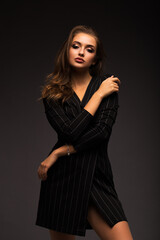 Portrait of a beautiful brunette on a gray isolated background. Luxurious girl with beautiful lips.