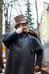 Respectable mustachioed man in classic retro clothes, coat and hat.