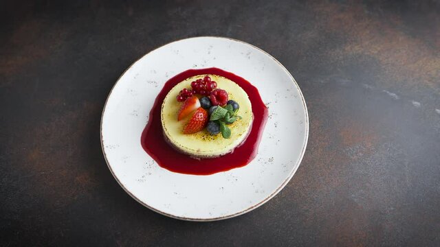 top view of a delicious dessert. Tiramisu or cheesecake garnished with mint and fresh berries.