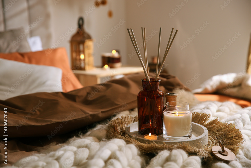 Wall mural Air reed freshener and burning candles on bed indoors, space for text. Interior elements