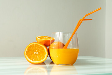 Orange juice in a glass with some oranges around