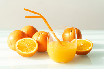 Orange juice in a glass with some oranges around