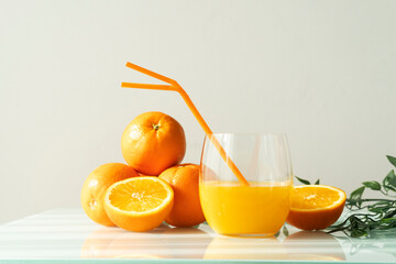 Orange juice in a glass with some oranges around