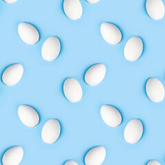 Two white wooden eggs seamless pattern on bright light blue background.
