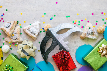 Purim celebration concept (jewish carnival holiday) on white background, top view, copy space. flat lay with hamantaschen cookies and purim mask.