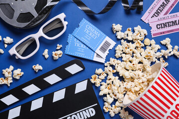 Flat lay composition with clapperboard, cinema tickets and 3d glasses on blue background