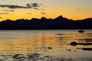 beautiful colours behind mountain range and in fjord as the sun is going down