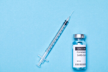 Vaccine bottles, vials medicine and syringe injection isolated on blue. Coronavirus 2019-ncov.