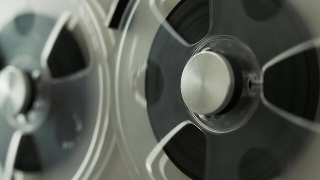 Reel To Reel Tape Recorder Playing. Rotating Vintage Music Player Close Up. Retro Tape. Spinning Reels Metallic Color. View from Above. Popular Disco Trends 60s, 70s, 80s, 90s.