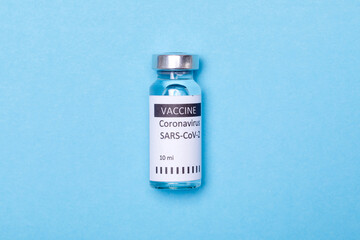 Vaccine bottles, vials medicine and syringe injection isolated on blue. Coronavirus 2019-ncov.