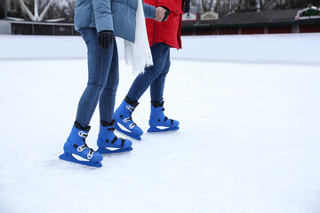 Naklejka premium Couple skating along ice rink outdoors, closeup
