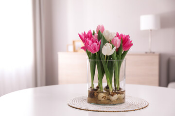 Bouquet of beautiful tulips with bulbs on table indoors. Space for text