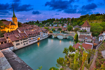 Skyline of Bern, capital of Switzerland at blue hour reflecting in Aare river. Panoramic view of...