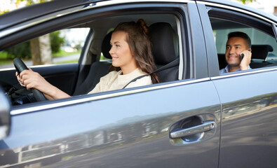 transportation, vehicle and people concept - happy smiling female driver driving car with male...