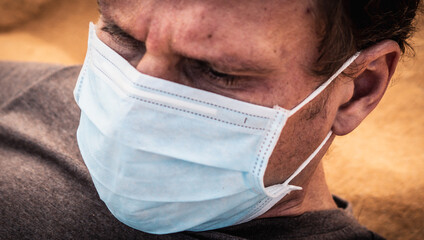 Close-up side portrait man wear protect mask, face expression emotion, furrowed brow wrinkle, look...