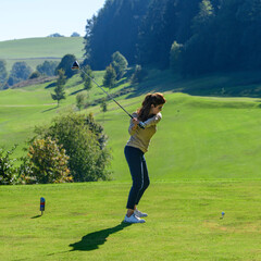 Golferin beim Abschlag vom Tee