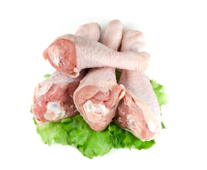 Raw chicken legs and green salad isolated on white background.